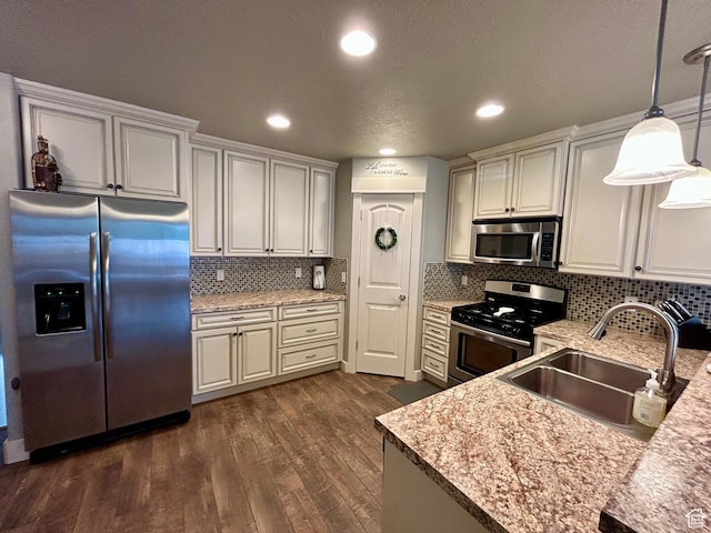 319 S 600 E, Payson, UT 84651 - kitchen featuring appliances with stainless steel finishes, a sink, dark wood finished floors, decorative light fixtures, and decorative backsplash