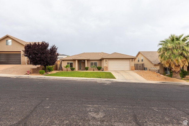 1500 E Mesa View Ln, Washington, UT 84780 - view of front of house with stucco siding, driveway, a garage, and stone siding