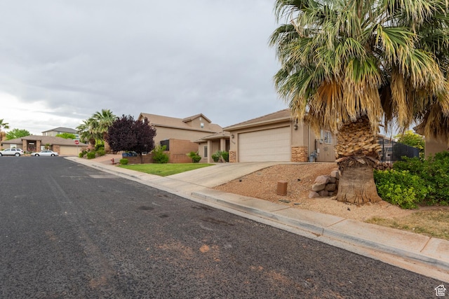 1500 E Mesa View Ln, Washington, UT 84780 - view of property hidden behind natural elements with stucco siding, driveway, a garage, and stone siding