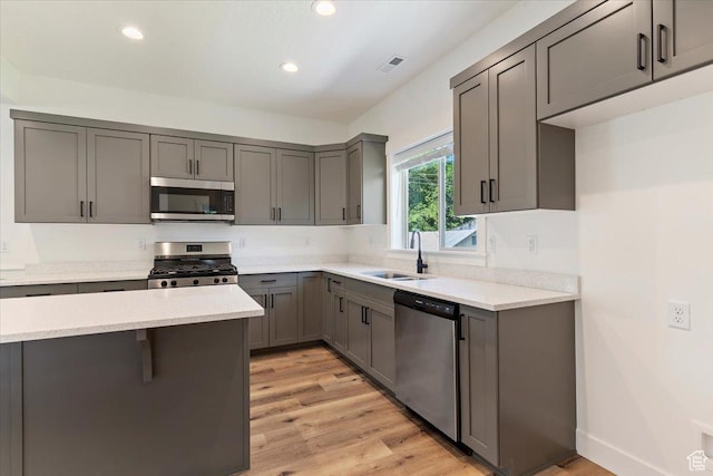 874 Cahoon St, Ogden, UT 84401 - kitchen featuring appliances with stainless steel finishes, a sink, light wood-style flooring, recessed lighting, and gray cabinetry