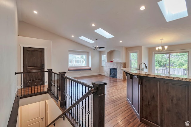 222 E 905 N, Orem, UT 84057 - kitchen with a skylight, a fireplace, wood finished floors, dark brown cabinetry, and lofted ceiling