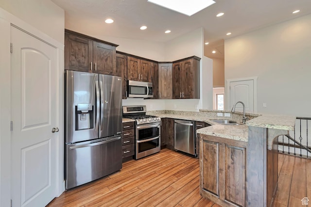 222 E 905 N, Orem, UT 84057 - kitchen with stainless steel appliances, a sink, a peninsula, light stone counters, and dark brown cabinetry