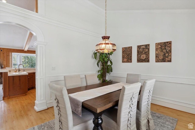 595 E 100 S, Morgan, UT 84050 - dining room with arched walkways, light wood finished floors, a decorative wall, wainscoting, and ornamental molding
