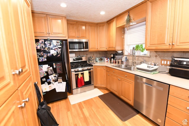 145 E 100 S, Farmington, UT 84025 - kitchen with appliances with stainless steel finishes, light wood-style floors, light countertops, tasteful backsplash, and a textured ceiling