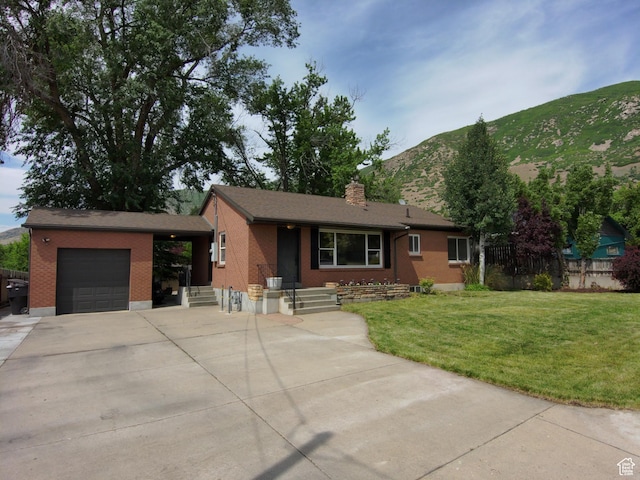 145 E 100 S, Farmington, UT 84025 - ranch-style house featuring an attached garage, a mountain view, a front yard, brick siding, and a chimney