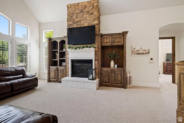 2908 W Bison Ridge Rd, South Jordan, UT 84095 - living room with a fireplace, light carpet, arched walkways, baseboards, and high vaulted ceiling
