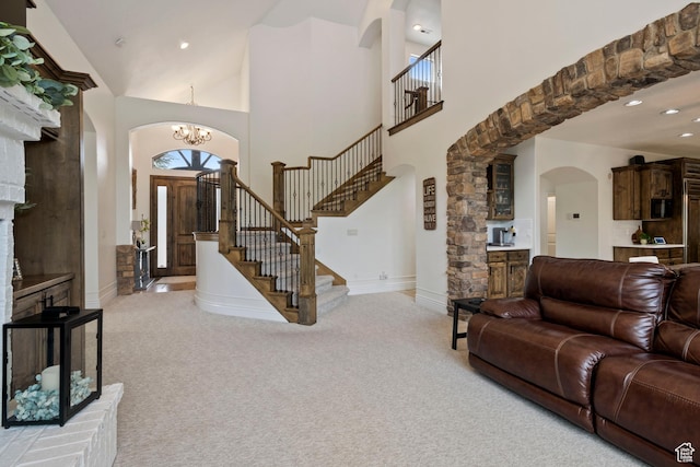 2908 W Bison Ridge Rd, South Jordan, UT 84095 - living area with arched walkways, light colored carpet, stairway, a chandelier, and a high ceiling
