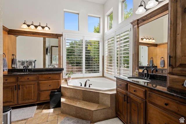 2908 W Bison Ridge Rd, South Jordan, UT 84095 - bathroom featuring stone tile flooring, two vanities, a bath, and a towering ceiling