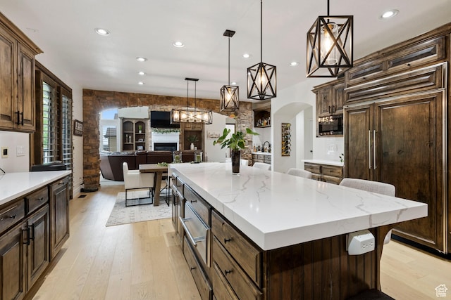 2908 W Bison Ridge Rd, South Jordan, UT 84095 - kitchen featuring built in appliances, recessed lighting, light wood-style flooring, arched walkways, and decorative light fixtures