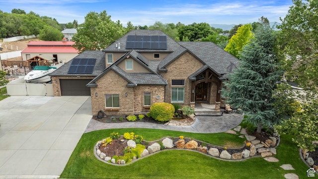 2908 W Bison Ridge Rd, South Jordan, UT 84095 - view of front of home with concrete driveway, a shingled roof, brick siding, and roof mounted solar panels