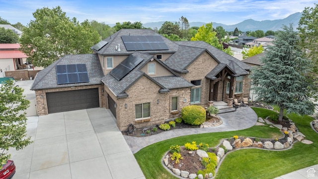2908 W Bison Ridge Rd, South Jordan, UT 84095 - view of front of property with roof mounted solar panels, concrete driveway, roof with shingles, a front yard, and brick siding