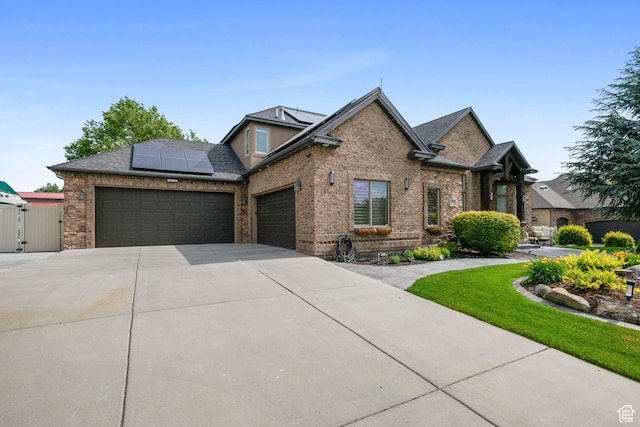 2908 W Bison Ridge Rd, South Jordan, UT 84095 - view of front of property with a garage, driveway, solar panels, a gate, and brick siding