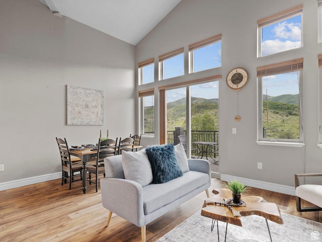 6749 N 2200 W Unit B-303, Park City, UT 84098 - living room with a mountain view, baseboards, high vaulted ceiling, and light wood finished floors
