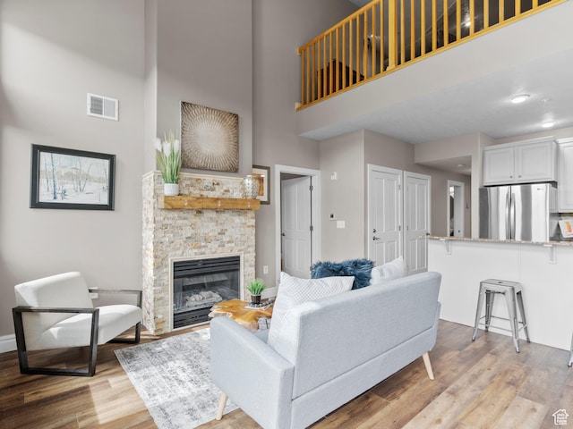 6749 N 2200 W Unit B-303, Park City, UT 84098 - living area with a high ceiling, light wood-style floors, a fireplace, and baseboards