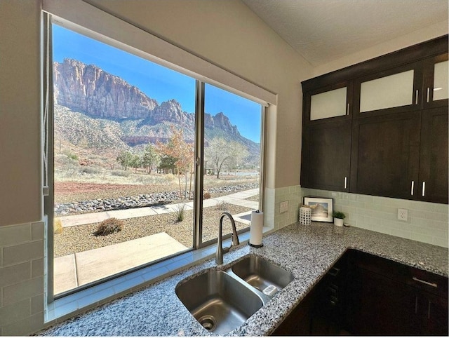 108 Trapper Cir Unit A, Springdale, UT 84767 - kitchen featuring a sink, light stone counters, a mountain view, glass insert cabinets, and tasteful backsplash