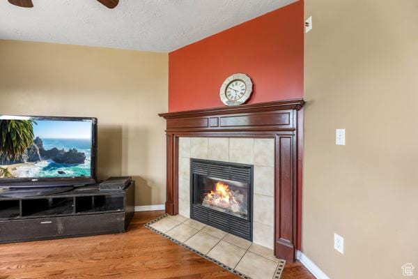 755 E 890 N, Tooele, UT 84074 - detailed view of a ceiling fan, wood finished floors, a tiled fireplace, baseboards, and a textured ceiling