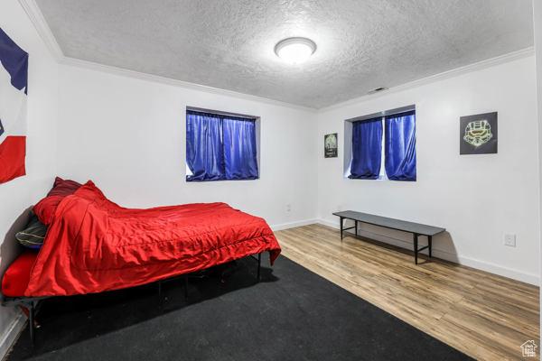 755 E 890 N, Tooele, UT 84074 - bedroom featuring a textured ceiling, crown molding, wood finished floors, and baseboards