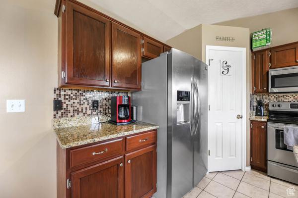755 E 890 N, Tooele, UT 84074 - kitchen with stainless steel appliances, backsplash, light tile patterned floors, and light stone countertops