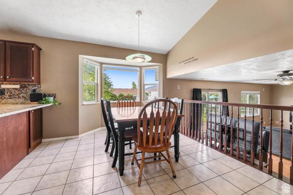 755 E 890 N, Tooele, UT 84074 - dining space featuring light tile patterned floors, plenty of natural light, a ceiling fan, and lofted ceiling