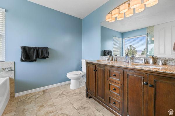 755 E 890 N, Tooele, UT 84074 - full bathroom featuring a garden tub, double vanity, baseboards, and toilet