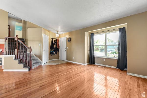 755 E 890 N, Tooele, UT 84074 - unfurnished living room featuring wood-type flooring, baseboards, and stairs