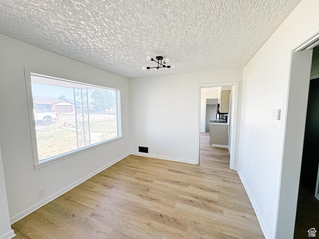 1797 N 5900 W, Warren, UT 84404 - unfurnished dining area featuring light wood finished floors, a textured ceiling, and baseboards
