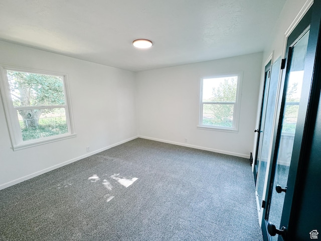 1797 N 5900 W, Warren, UT 84404 - empty room with plenty of natural light, dark colored carpet, and baseboards