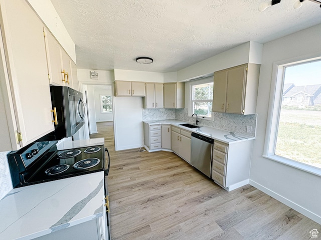 1797 N 5900 W, Warren, UT 84404 - kitchen with appliances with stainless steel finishes, a textured ceiling, a sink, light wood-style flooring, and light countertops