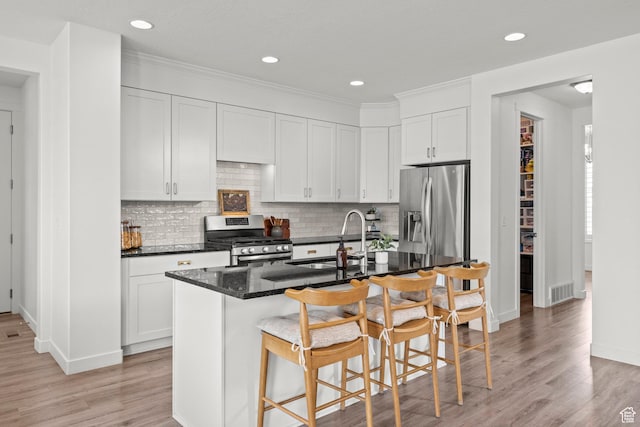 1314 W 1550 N, Lehi, UT 84043 - kitchen featuring stainless steel appliances, a sink, a kitchen bar, light wood finished floors, and tasteful backsplash