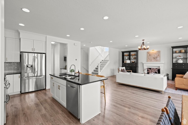 1314 W 1550 N, Lehi, UT 84043 - kitchen with stainless steel appliances, dark countertops, a sink, recessed lighting, and wood finished floors