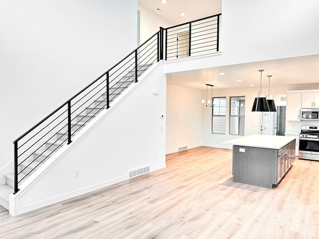 11208 S Easy Bee St Unit 268, South Jordan, UT 84009 - kitchen featuring stainless steel appliances, light wood-style floors, a kitchen island, recessed lighting, and decorative light fixtures