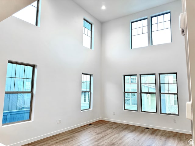 11208 S Easy Bee St Unit 268, South Jordan, UT 84009 - unfurnished room with a towering ceiling, wood finished floors, and baseboards