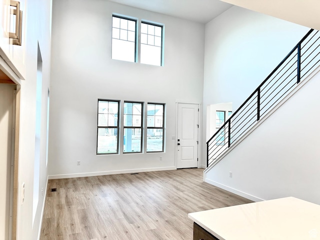 11208 S Easy Bee St Unit 268, South Jordan, UT 84009 - entrance foyer with a towering ceiling, light wood finished floors, stairs, healthy amount of natural light, and baseboards