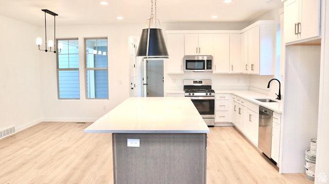 11208 S Easy Bee St Unit 268, South Jordan, UT 84009 - kitchen with stainless steel appliances, a sink, a kitchen island, light wood-type flooring, and recessed lighting