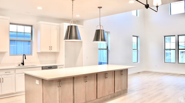 11208 S Easy Bee St Unit 268, South Jordan, UT 84009 - kitchen with a sink, a kitchen island, light wood-type flooring, light countertops, and white cabinetry