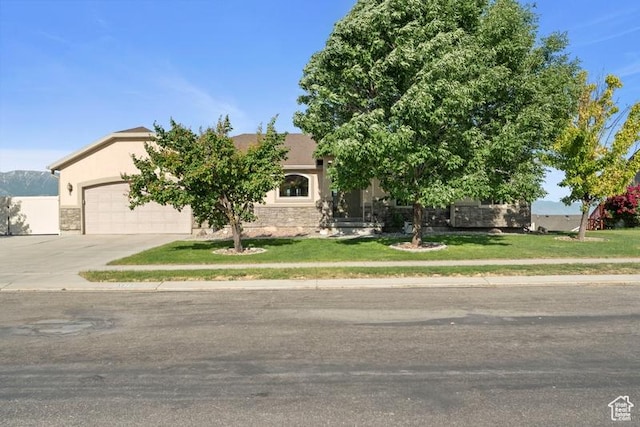 3972 S Lake Vista Dr, Saratoga Springs, UT 84045 - view of property hidden behind natural elements featuring concrete driveway, stucco siding, an attached garage, stone siding, and a front lawn