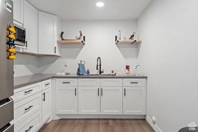 3972 S Lake Vista Dr, Saratoga Springs, UT 84045 - kitchen with open shelves, a sink, white cabinets, light wood finished floors, and recessed lighting