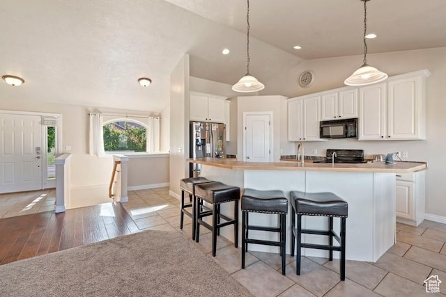 3972 S Lake Vista Dr, Saratoga Springs, UT 84045 - kitchen featuring black microwave, stainless steel fridge with ice dispenser, lofted ceiling, baseboards, and white cabinetry
