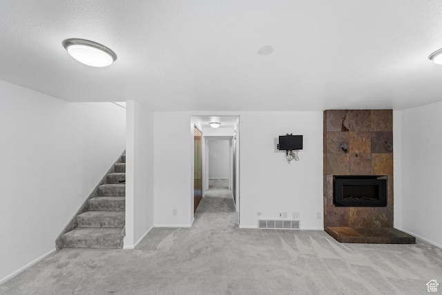 42 Benchmark Vlg, Tooele, UT 84074 - unfurnished living room featuring carpet, stairs, a tile fireplace, and baseboards