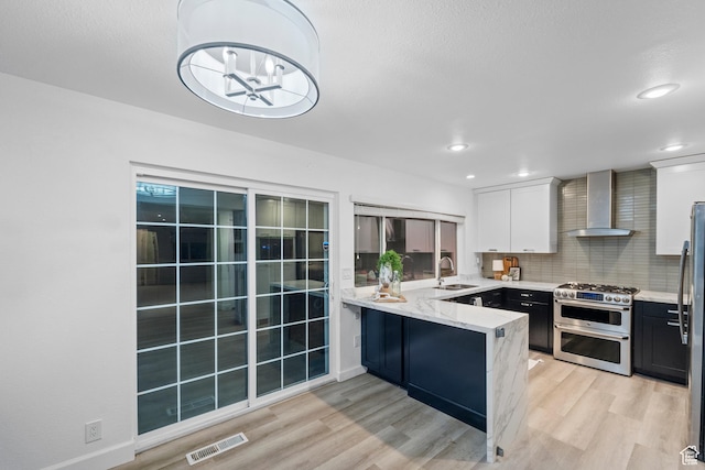 42 Benchmark Vlg, Tooele, UT 84074 - kitchen featuring wall chimney range hood, double oven range, light wood-type flooring, a sink, and recessed lighting