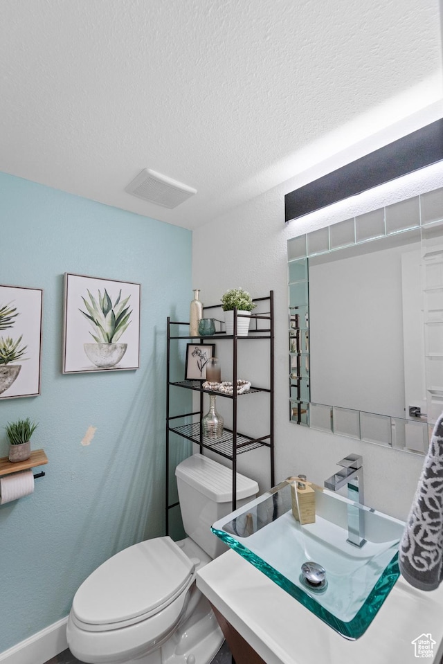 42 Benchmark Vlg, Tooele, UT 84074 - half bathroom featuring toilet, vanity, and a textured ceiling