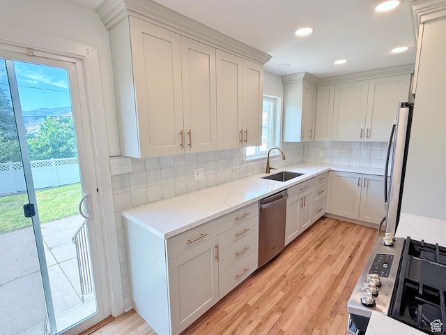 573 E 1600 S, Bountiful, UT 84010 - kitchen featuring stainless steel appliances, a sink, light wood-style floors, decorative backsplash, and light stone countertops