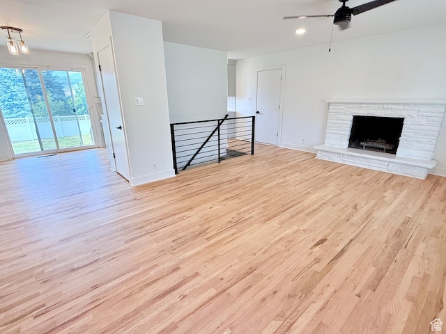 573 E 1600 S, Bountiful, UT 84010 - unfurnished living room with wood finished floors, ceiling fan, baseboards, and a stone fireplace