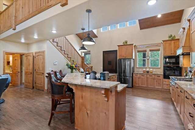 145 N 10450 E, Huntsville, UT 84317 - kitchen featuring black appliances, a kitchen bar, dark wood-style flooring, a towering ceiling, and a center island