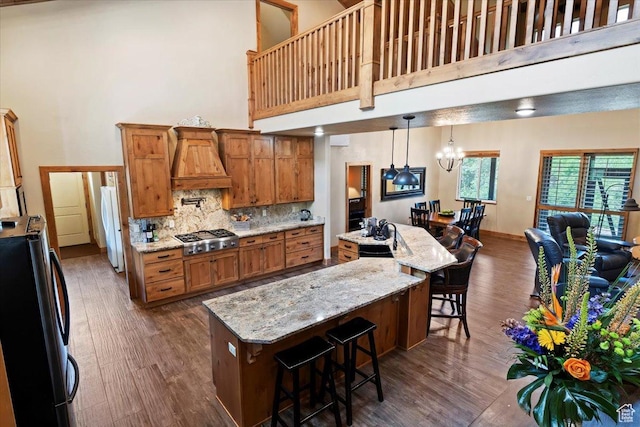 145 N 10450 E, Huntsville, UT 84317 - kitchen featuring refrigerator, a towering ceiling, stainless steel gas cooktop, premium range hood, and brown cabinetry