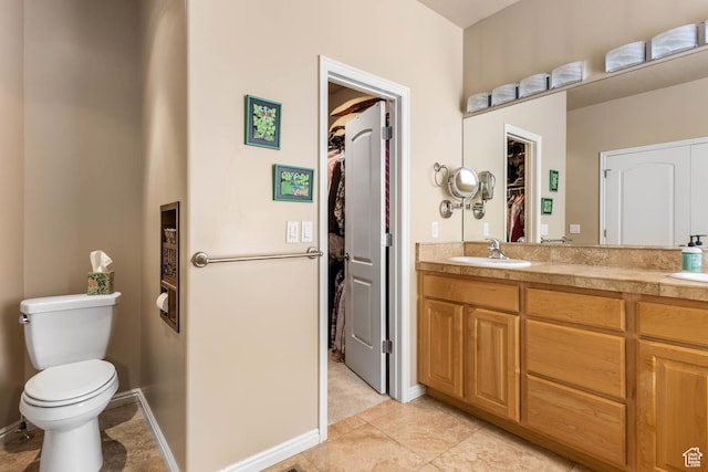 1111 E Bench View Dr, Ogden, UT 84404 - full bath with a spacious closet, double vanity, toilet, tile patterned floors, and baseboards