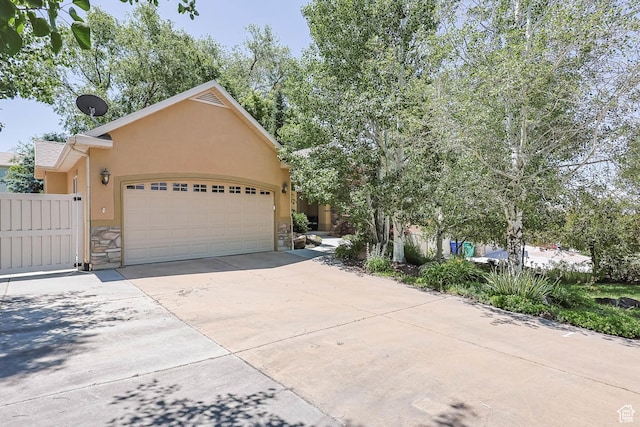 1111 E Bench View Dr, Ogden, UT 84404 - view of front of home featuring stone siding, stucco siding, an attached garage, and driveway