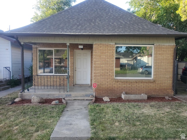 530 E 31st St, Ogden, UT 84403 - view of front of home featuring roof with shingles, covered porch, brick siding, and a front lawn
