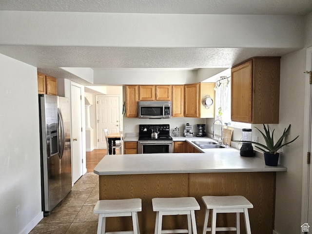 506 E 670 N, Tooele, UT 84074 - kitchen with appliances with stainless steel finishes, a sink, a peninsula, light countertops, and baseboards