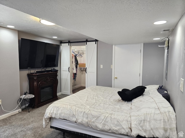 506 E 670 N, Tooele, UT 84074 - bedroom featuring a barn door, a walk in closet, carpet, a textured ceiling, and baseboards